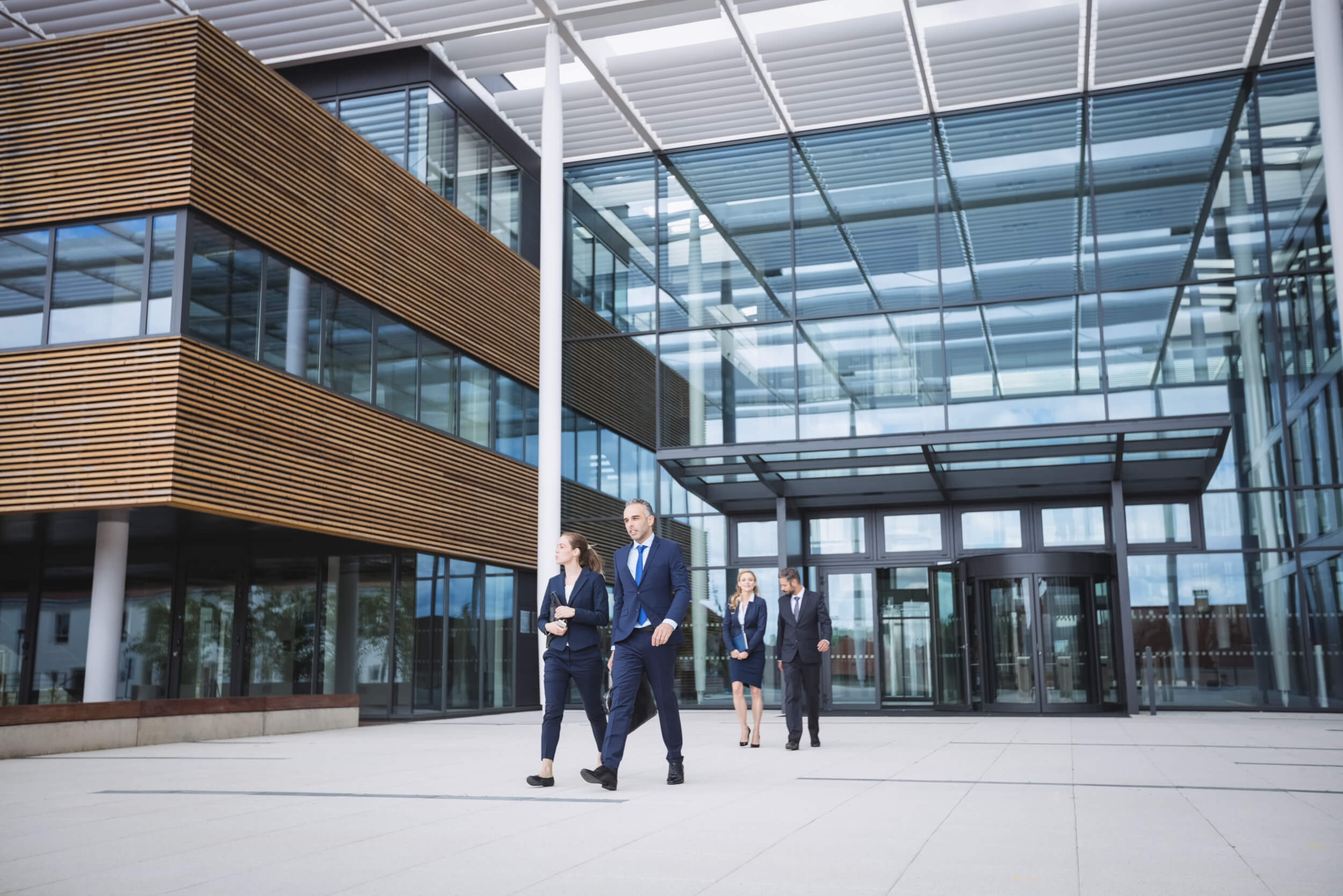 Group of business people walking outside the entrance of an office building advokát-bratislava-krypto-slovakia