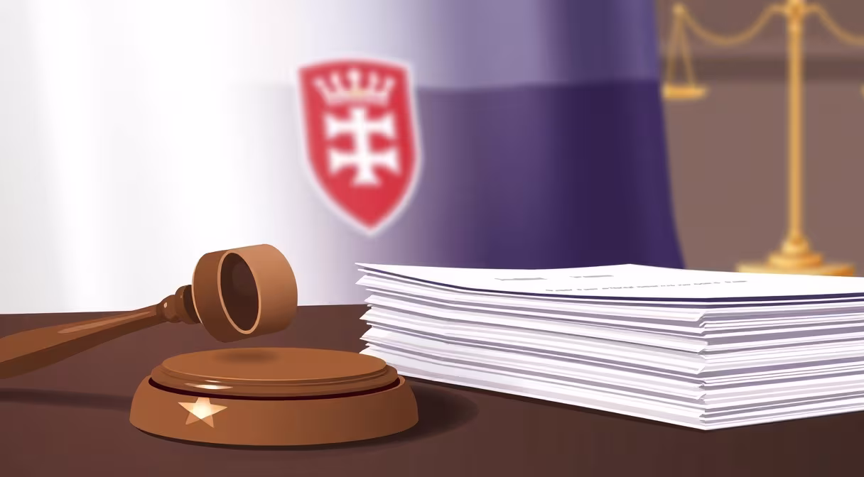Kladivo na stole s hromadou formulárov a slovenskou zástavou ako symbol daňového priznania.