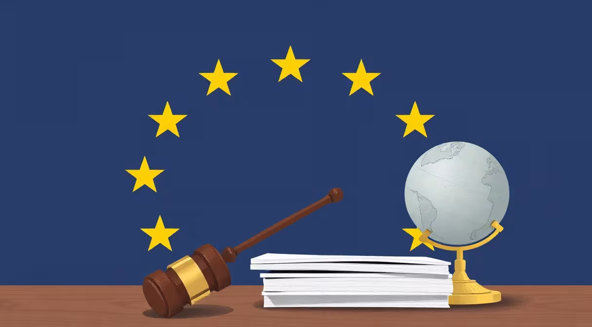 Gavel na dokumentoch s glóbusom a vlajkou EÚ v pozadí, symbolizujúce sociálne zabezpečenie.