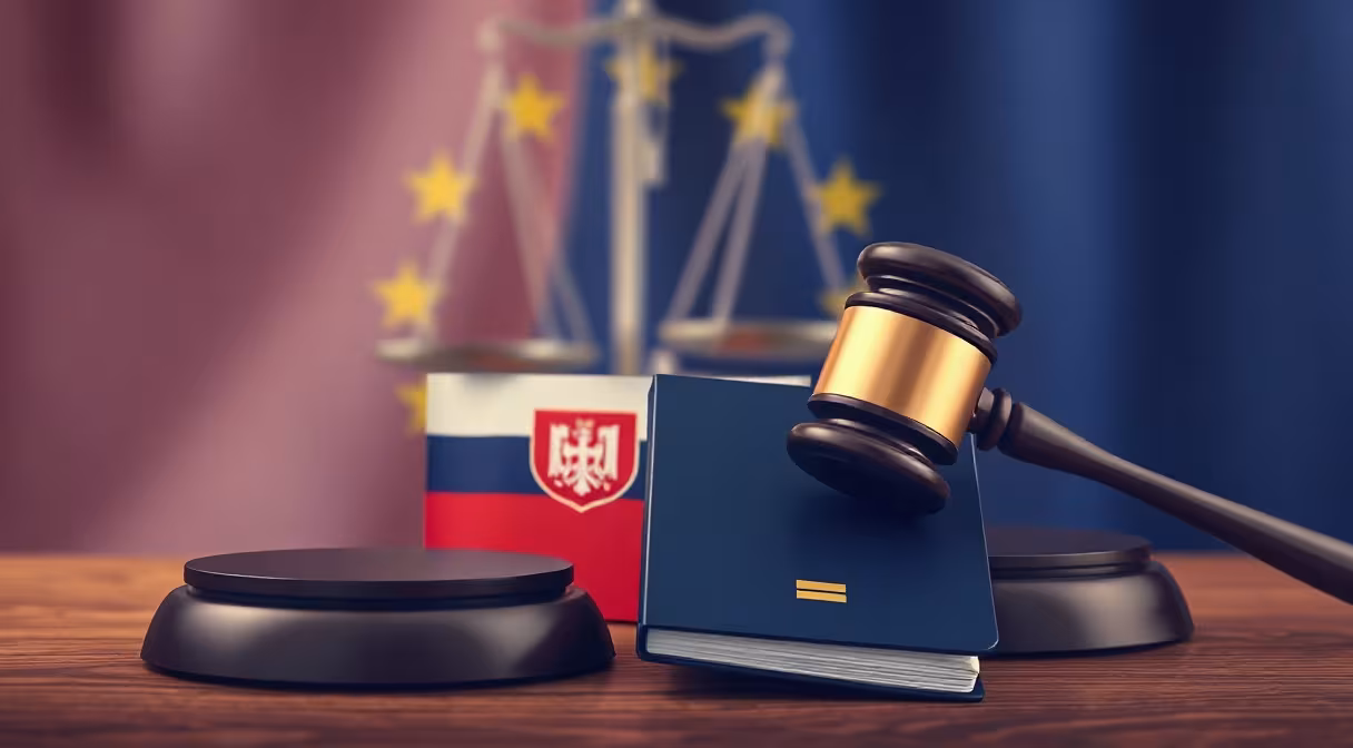 Pas a slovenská vlajka na stole s kladivom symbolizujúce nový zákon o pobyte cudzincov.