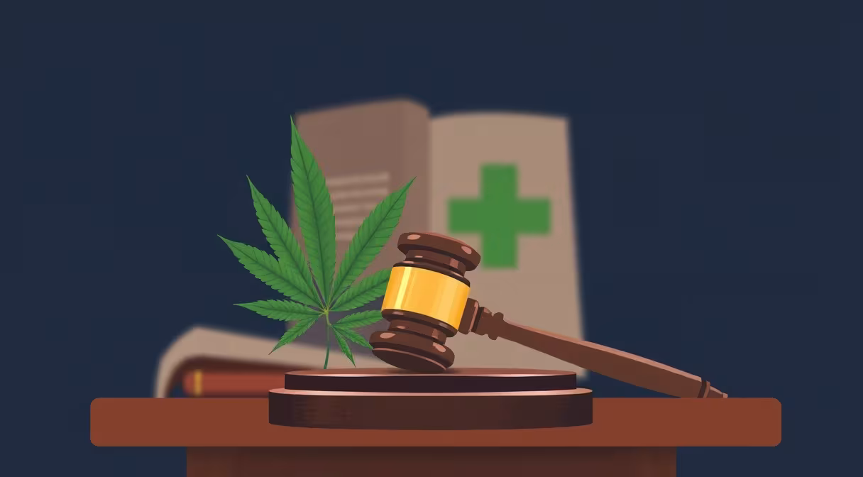 Súdne kladivo na pódiu vedľa listu konope a zeleného kríža, ilustrujúce legalizáciu CBD na Slovensku.